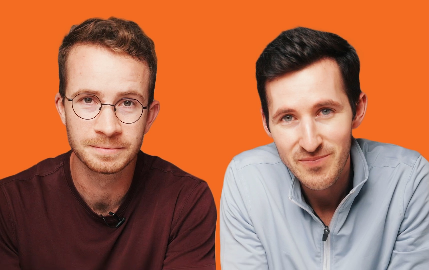 Tight shot of Kasper and David leaning slightly forward looking at the camera on a vibrant orange background.